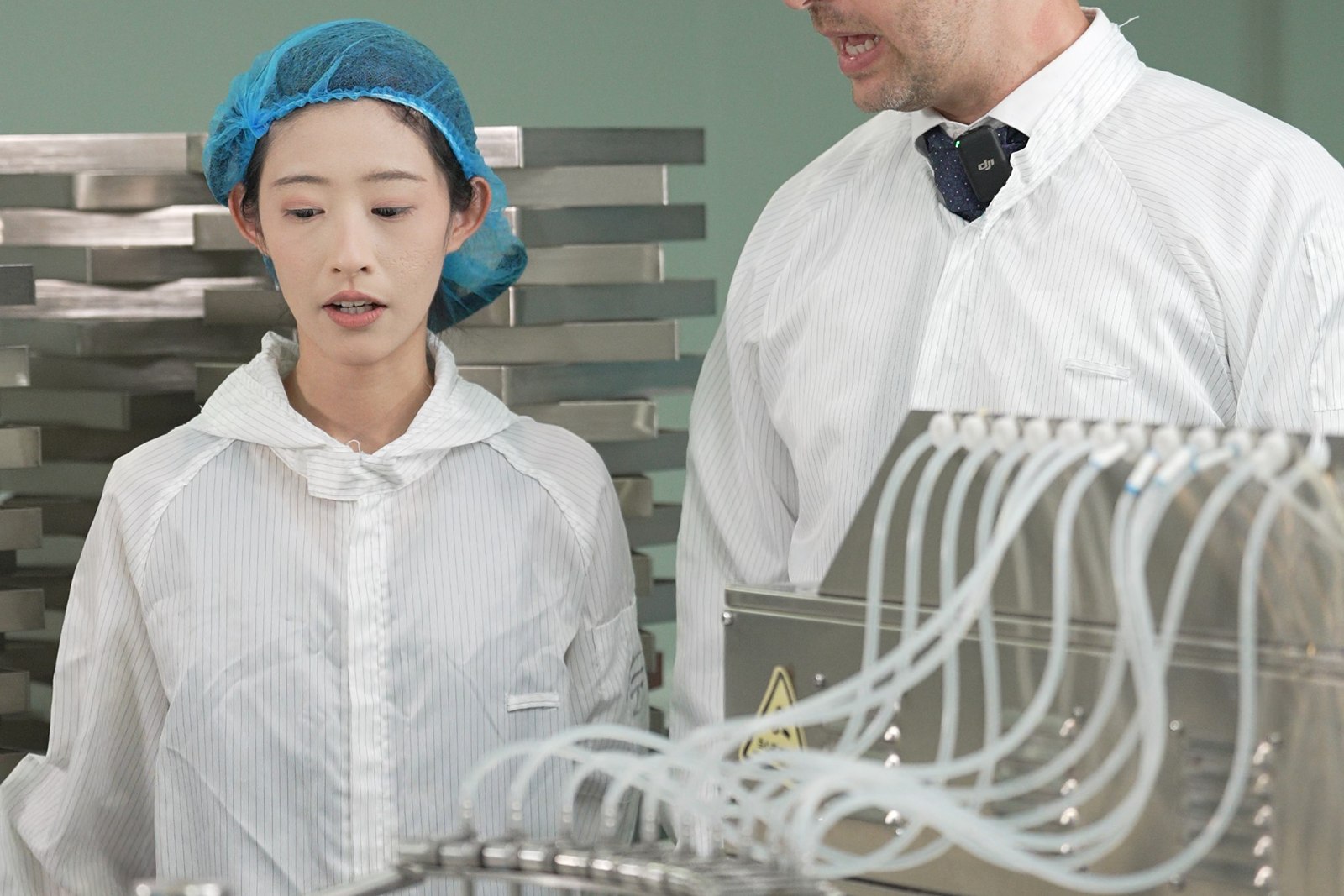 Technician walking a visiting buyer through the vial filling machine on the production floor